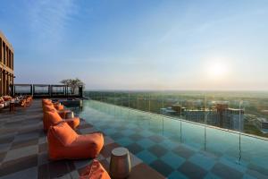 - une piscine avec des chaises orangées au-dessus d'un bâtiment dans l'établissement Centara Ayutthaya, à Phra Nakhon Si Ayutthaya