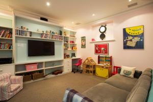 salon z kanapą i telewizorem z płaskim ekranem w obiekcie Victorian Masterpiece w mieście Sydney