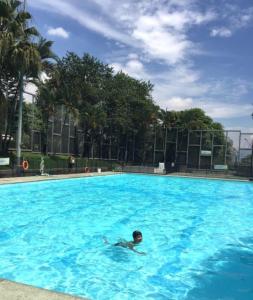 a boy swimming in a large blue swimming pool at Apartamento en el cerro la Asomadera in Medellín