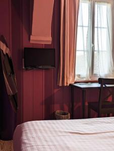 a bedroom with a bed and a tv on the wall at Hotel du Saumon, Verneuil sur Avre in Verneuil d’Avre et d’Iton