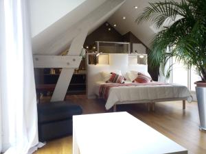 ein Schlafzimmer mit einem großen Bett und einer Treppe in der Unterkunft B&B Loft Trotters in LʼÉtang-la-Ville
