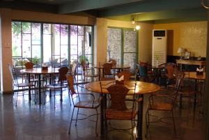 un comedor con mesas, sillas y ventanas en shillahotel and resort en Ángeles