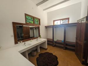 baño con 2 lavabos y espejo grande en Kivulini Lodge, en Utende
