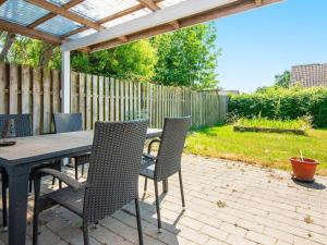 un patio con mesa, sillas y una valla en 4 person holiday home in Sydals, en Østerby