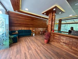 - un salon avec un canapé bleu et un bar dans l'établissement Suvarna Eco Village, à Madikeri