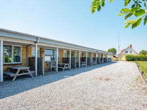 a row of buildings with chairs and a picnic table at 4 person holiday home in Sydals in Østerby