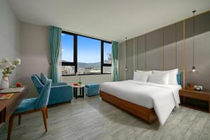 a bedroom with a large bed and a blue couch at Lupin Center Da Nang Hotel in Danang