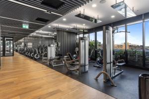 a gym with treadmills and elliptical machines at Chic 1-Bed with Parking, Rooftop Pool and Gym in Brisbane