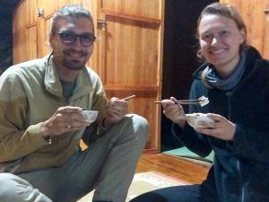 a man and a woman eating food with chopsticks at Trieu Hoan homestay in Cao Bằng