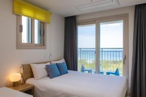 a bedroom with two beds and a large window at Blue12 Yangyang Neos in Yangyang