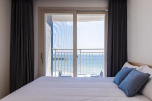 a bedroom with a bed with a view of the ocean at Blue12 Yangyang Neos in Yangyang