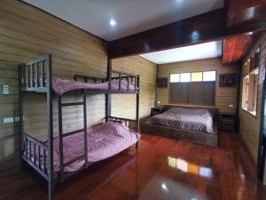 にあるรักบ้านไม้ Rak Baan Maiの木製の壁の客室で、二段ベッド2組が備わります。