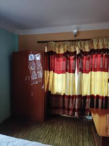 a bedroom with a bed and a curtain at Pauwa Garden Resort in Nagarkot