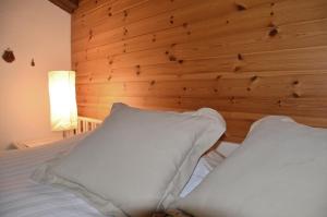a bedroom with a wooden wall and a bed with pillows at Chalet Memory in Zermatt