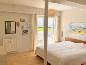 1 dormitorio con cama y ventana grande en 4 person holiday home in Gudhjem en Gudhjem