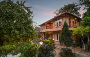 een huis met een groot terras aan de zijkant bij Summit Green Lake Tea Resort & Spa in Kāziranga