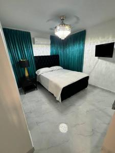 um quarto com uma cama com cortinas verdes e uma televisão em Best Place Cayenas 7 em La Grúa