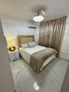 um quarto com uma cama e um candeeiro num piso em Best Place Cayenas 7 em La Grúa
