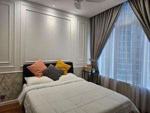 a bedroom with a bed with colorful pillows on it at Sky Suites KLCC Kuala Lumpur in Kuala Lumpur