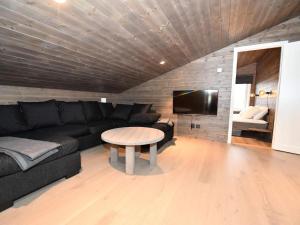 een woonkamer met een zwarte bank en een tafel bij 12 person holiday home in IDRE in Idre