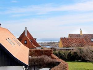 a group of houses with roofs and grass at 4 person holiday home in Svaneke in Svaneke