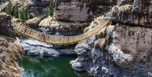 Un ponte su una scogliera sopra un corpo d'acqua di Hostal Inca a San Pedro