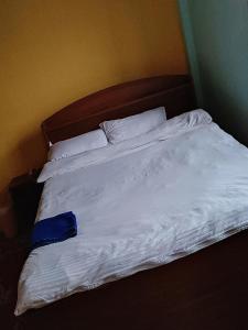 an unmade bed with white sheets and pillows at Pauwa Garden Resort in Nagarkot
