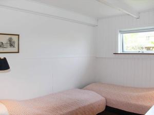 a bedroom with two beds and a window at 4 person holiday home in Svaneke in Svaneke