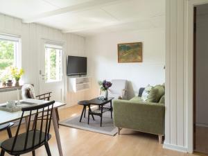 - un salon avec un canapé vert et une table dans l'établissement 4 person holiday home in Svaneke, à Svaneke