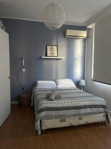 - une chambre dotée d'un lit avec un mur bleu dans l'établissement Home Sweet a mts Plaza Independencia, à Montevideo