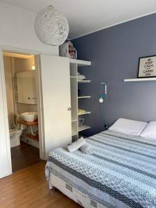 1 dormitorio con cama y pared azul en Home Sweet a mts Plaza Independencia, en Montevideo