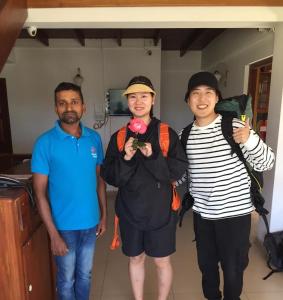 un groupe de trois personnes posant pour une photo dans l'établissement Thilina Hotel, à Nuwara Eliya