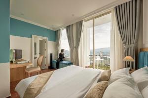 uma mulher num quarto de hotel com uma cama grande em D HOUSE DALAT 2 em Da Lat
