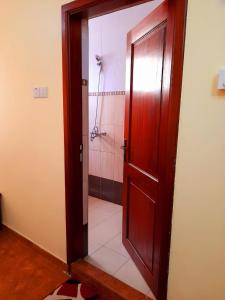 a door leading to a bathroom with a shower at IZAK HOTEL in Dar es Salaam