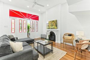 un soggiorno con divano e camino di Chic 3-Bed House with a Cosy Courtyard a Sydney