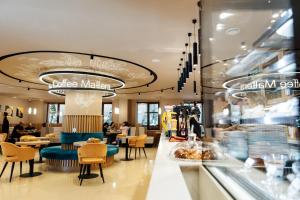 a restaurant with a counter and tables and chairs at Victoria Hotel in Oral