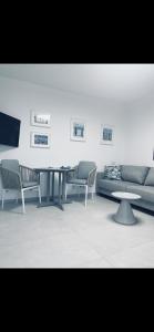 een woonkamer met een bank en een tafel en stoelen bij בלקוני לחוף דור in Dor