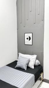 a bed in a room with white walls and white pillows at NgeKost harian in Alastuwo