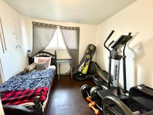 a bedroom with a bed and a room with a gym at Mountain View in Salt Lake City
