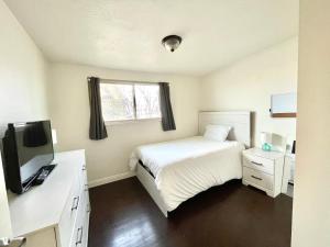 Dormitorio pequeño con cama y TV en Mountain View, en Salt Lake City