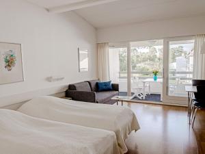 ein weißes Schlafzimmer mit einem Bett und ein Wohnzimmer in der Unterkunft 2 person holiday home in Nex in Neksø