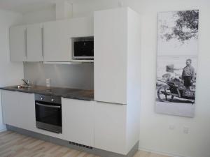 a kitchen with white cabinets and a microwave at 4 person holiday home in Svaneke in Svaneke