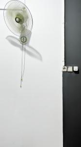 un ventilador blanco está pegado a una puerta en NgeKost harian, en Alastuwo