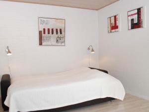 4 person holiday home in Allinge في إلينغه: غرفة نوم بيضاء بسرير ومصباحين