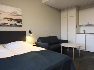 1 dormitorio con 1 cama, 1 silla y 1 mesa en 2 person holiday home in Allinge en Allinge