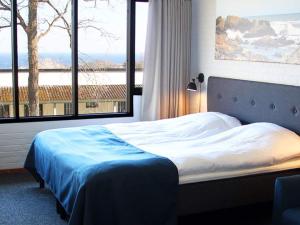 1 dormitorio con cama y ventana grande en 2 person holiday home in Allinge en Allinge