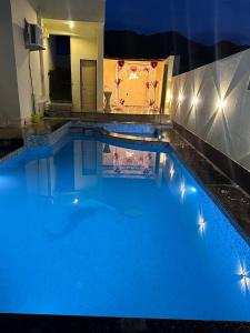 ein großer Pool mit blauem Wasser in der Nacht in der Unterkunft The heavens villa udaipur in Udaipur