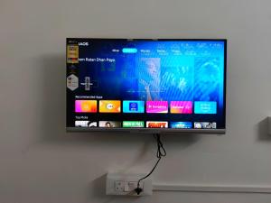 a flat screen tv hanging on a wall at AYYAN RESIDENCY in Alāndurai