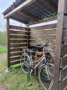 una bicicleta estacionada junto a un cobertizo de madera en Le petit Loir, gîte sur la Loire à vélo, 