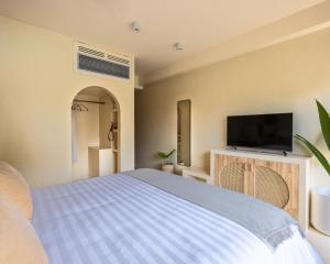 Fehendhoo的住宿－Isla Retreat，一间卧室配有一张床和一台平面电视